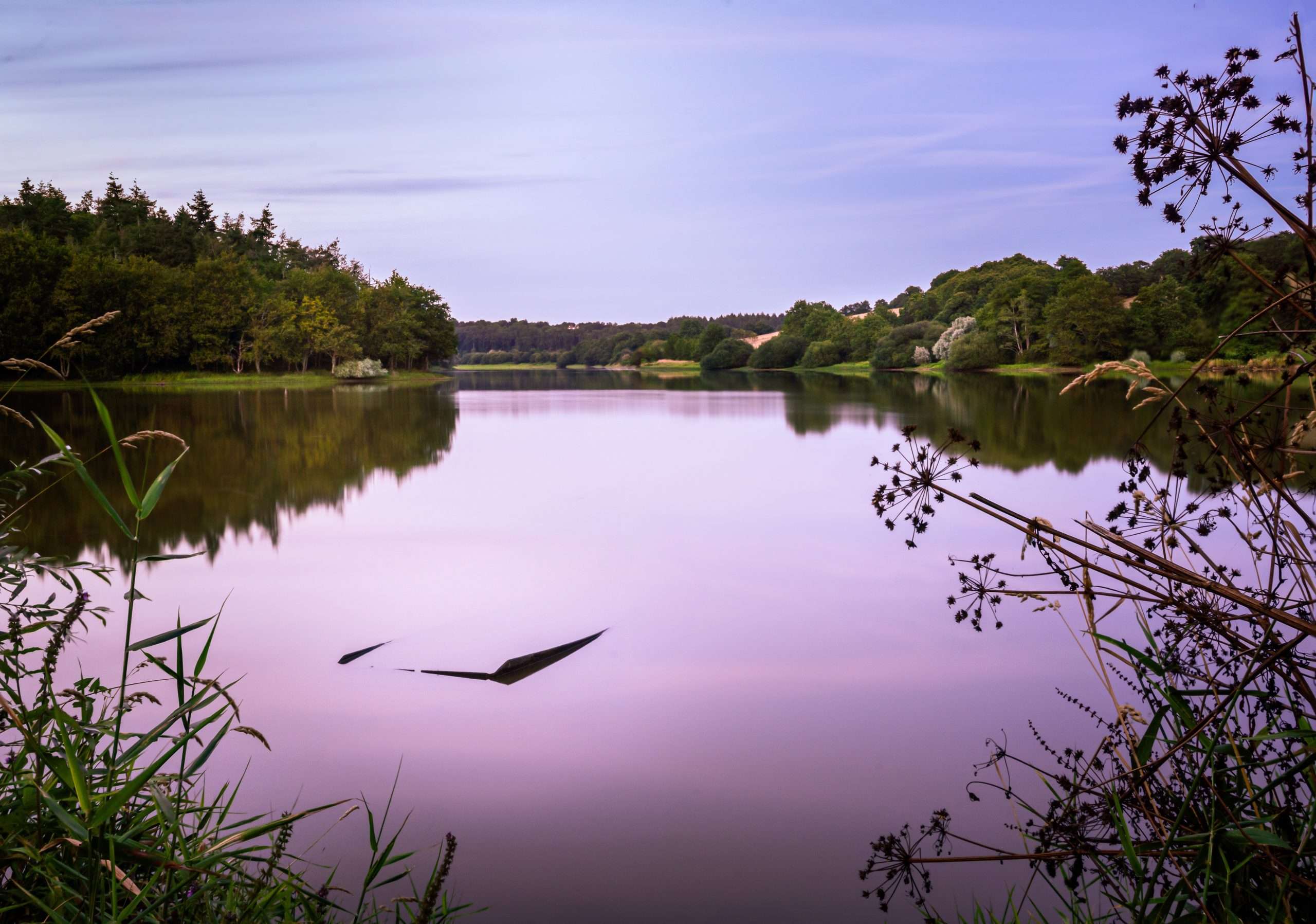 Breathtaking scenery of the sunset clouds reflecting in Lac du Jaunay lake, France